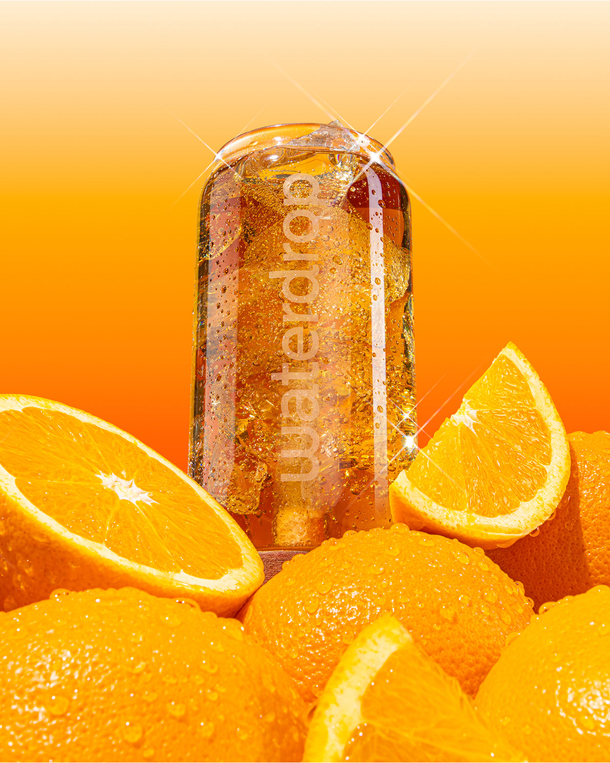Nápoj COLA ORANGE ve skleničce waterdrop® s logem a čerstvými pomeranči.
