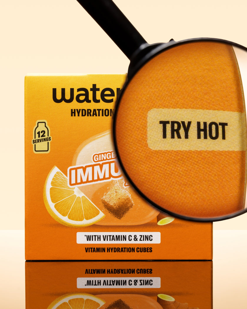 Oranžová krabice kostek hydratace s lupou nad oranžovou kostkou.