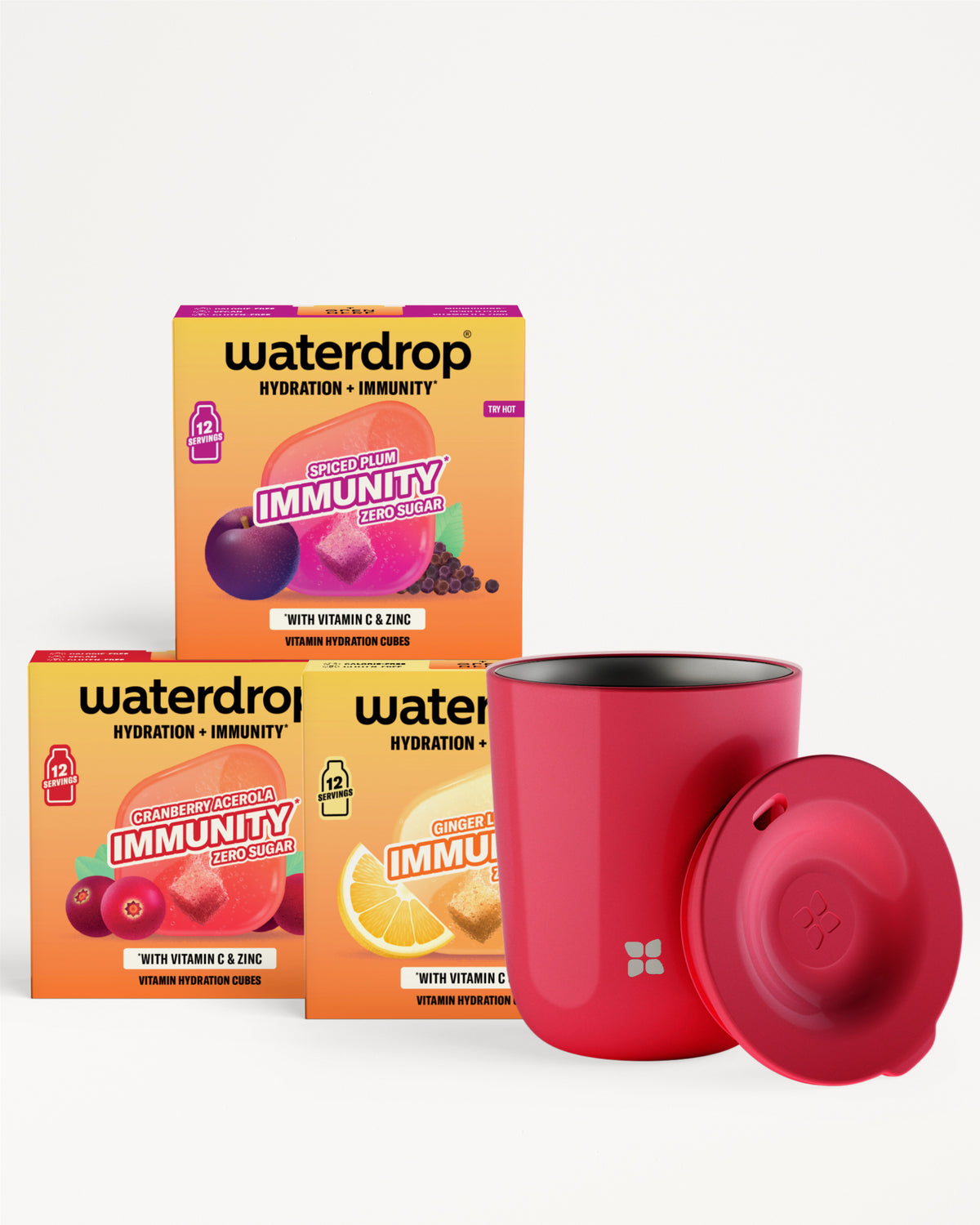 Tři oranžové krabičky produktu pro hydrataci a imunitu s červeným kelímkem a víčkem.