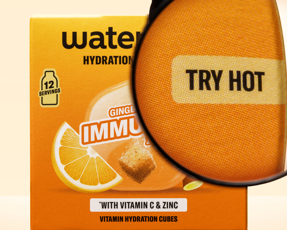 Oranžová krabice s grafikou citronu a zvětšovacím sklem překrývající, vitamínové hydratační kostky.