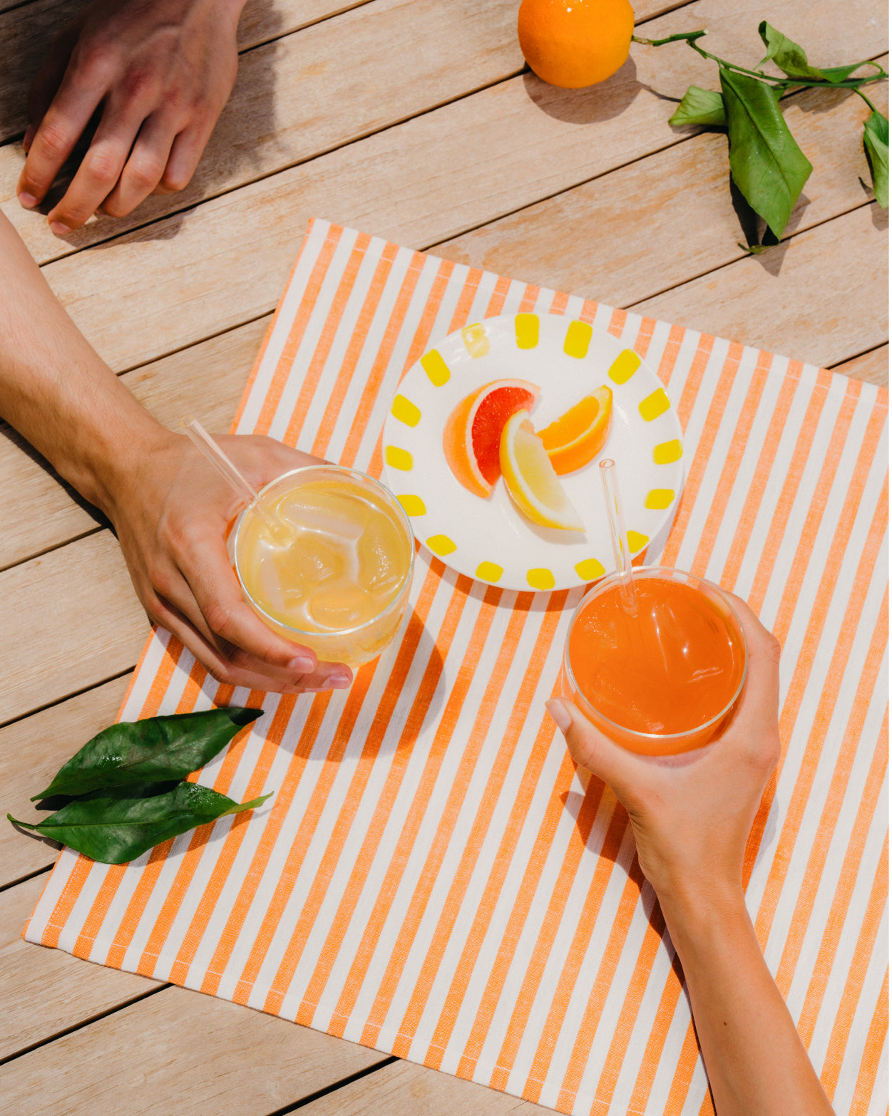 Best of Summer Set: Hand holding citrus-infused drink.